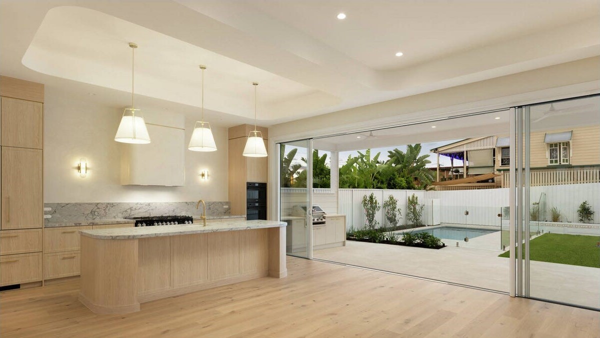 Luxury kitchen opening onto pool tiling completed by ID Tiling